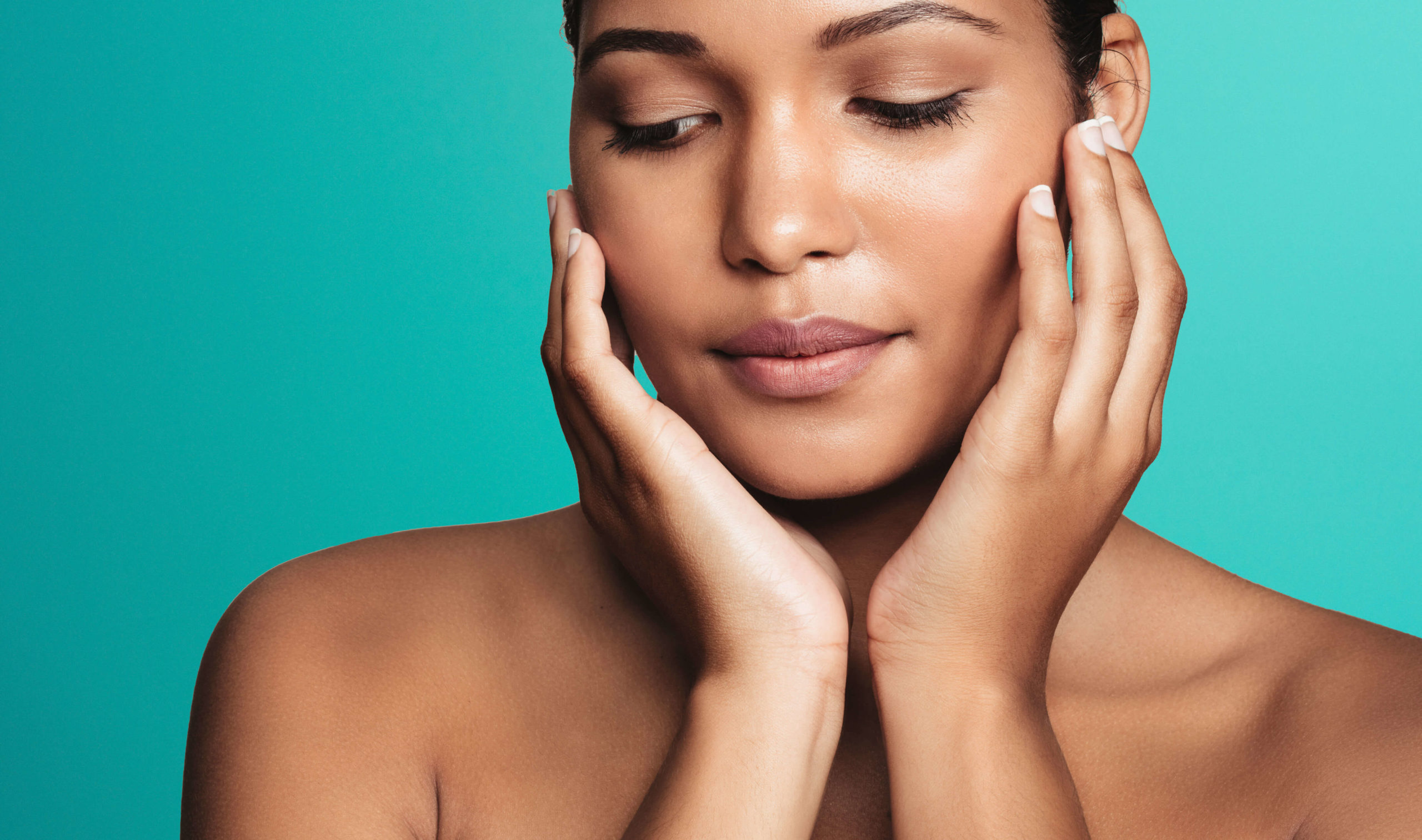 Sofwave ultrasound skin lifting London - close-up of a woman with eyes closed framing Close-up of a woman with eyes closed framing her face with both hands against for Sofwave ultrasound skin lifting in London