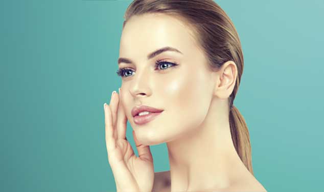 Sofwave ultrasound skin lifting London - woman in profile touching her cheek with one Woman in profile touching her cheek with one hand against a teal background for Sofwave ultrasound skin lifting in London